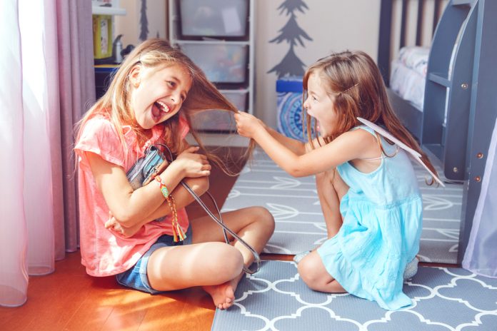 Two little mad angry girls sisters having fight at home. Friends